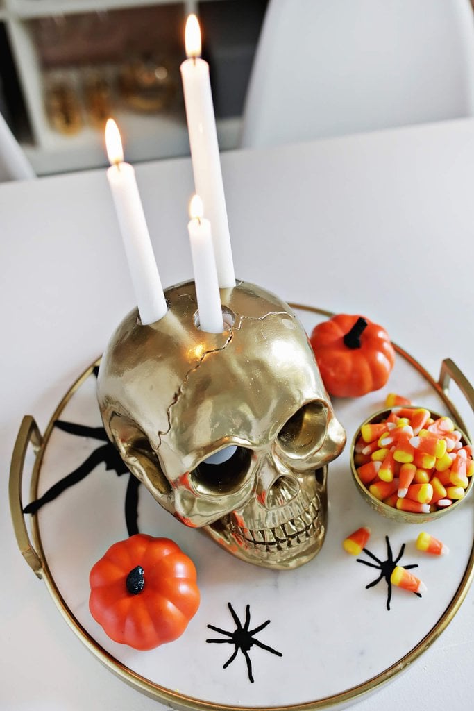A golden DIY candle-holder skull is spooky but also brings an element of glam rock to the soirée.