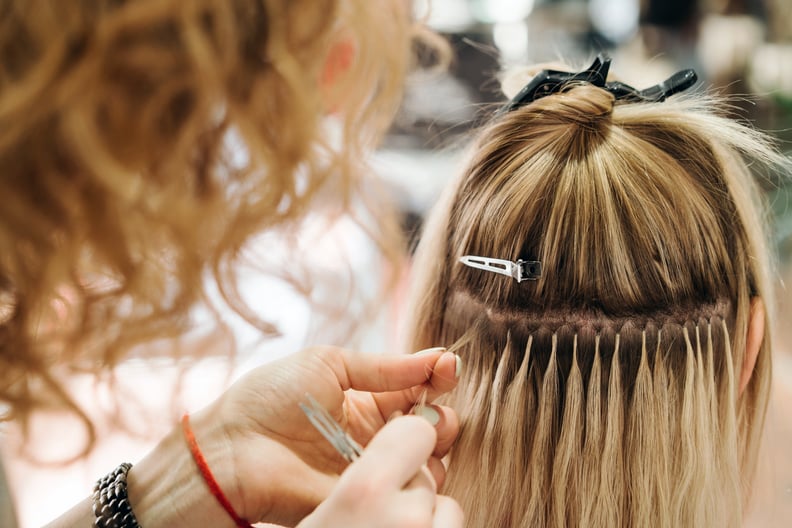 Girl hairdresser doing hairstyle styling for a middle-aged woman in a beauty salon. Hairdressing services. Beauty industry. Hair Extension Salon