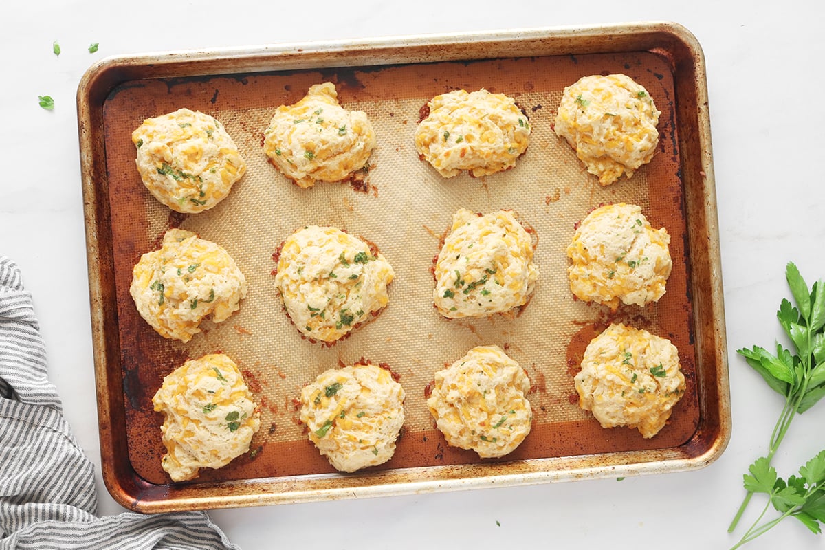 Baked copycat Red Lobster cheddar bay biscuits on a metal baking sheet