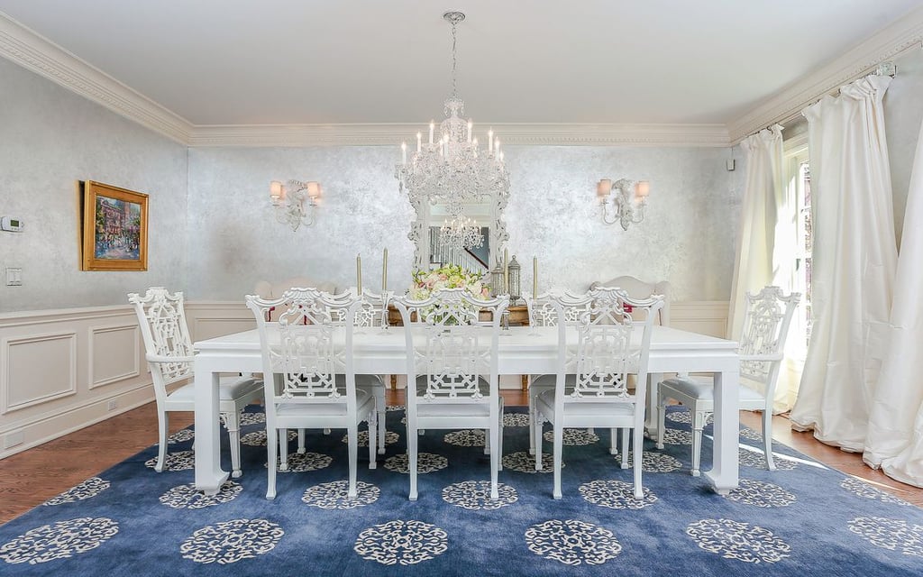 The dining room makes a big statement with metallic walls and a glamorous crystal light fixture.