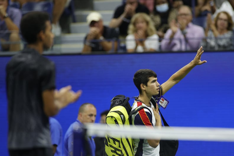 NEW YORK, NEW YORK - SEPTEMBER 07: Carlos Alcaraz of Spain looks waves to the crowd as he leaves the court after retiring during his Men's Singles quarterfinals match against Felix Auger-Aliassime of Canada during on Day Nine of the 2021 US Open at the US