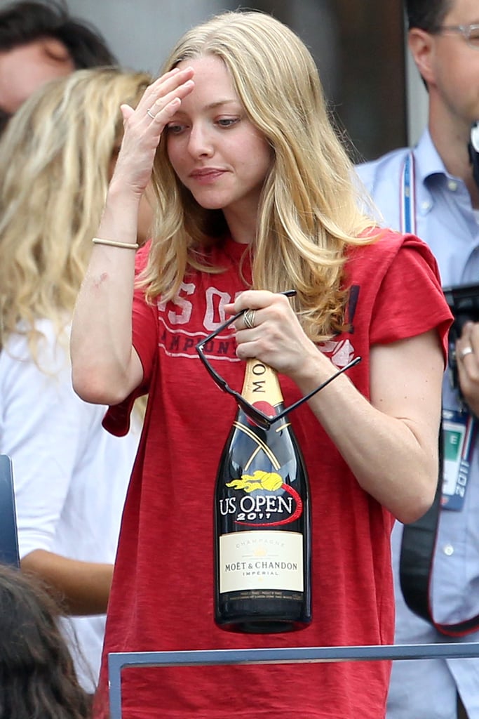 Amanda Seyfried clutched a bottle of Moët & Chandon at the US Open in September 2011.