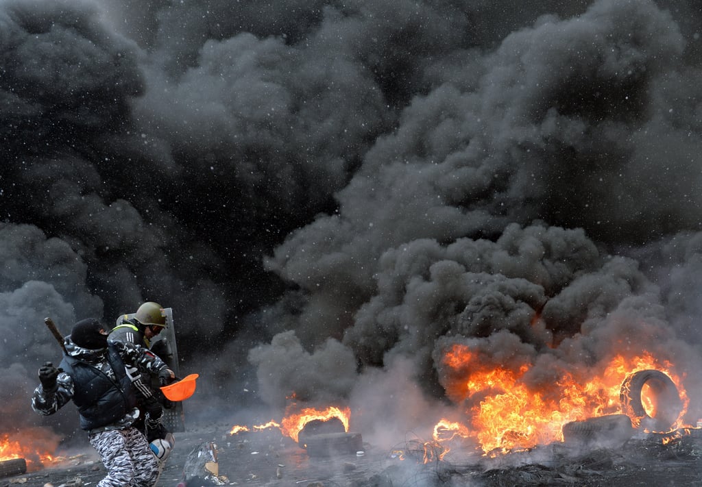 Protesters threw stones as smoke billowed above the barricade.