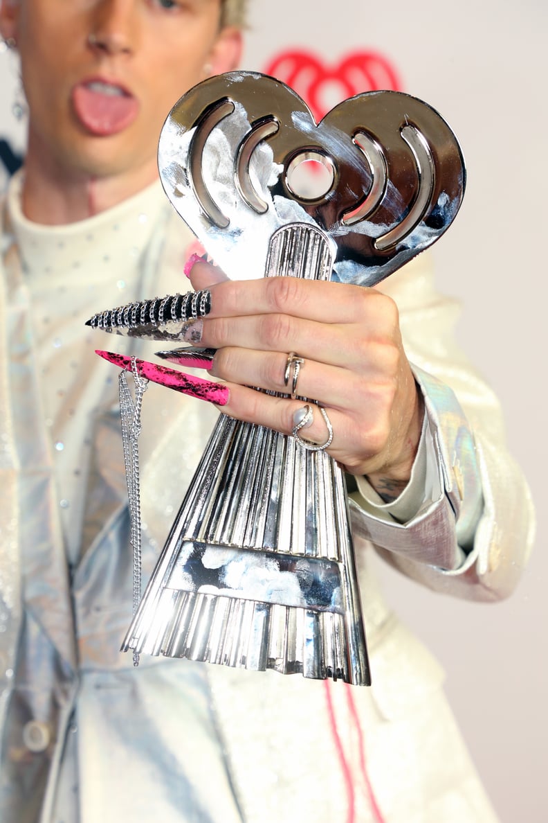 LOS ANGELES, CALIFORNIA - MAY 27: (EDITORIAL USE ONLY) Machine Gun Kelly, winner of the Alternative Rock Album of the Year award for 'Tickets To My Downfall,' trophy, manicure/nails, rings, and fashion details, attends the 2021 iHeartRadio Music Awards at