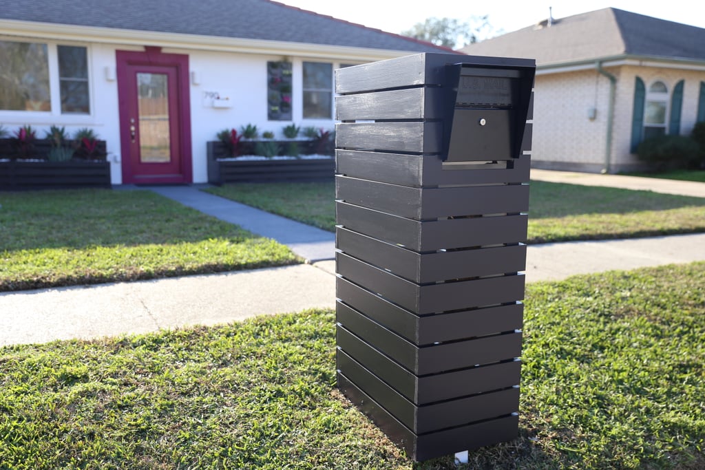 Instead of a tired old mailbox, Tiffany now has a work of art. Monica swapped in a new, sleek black mailbox ($98) and then encased it in domino-black-painted wood boards.