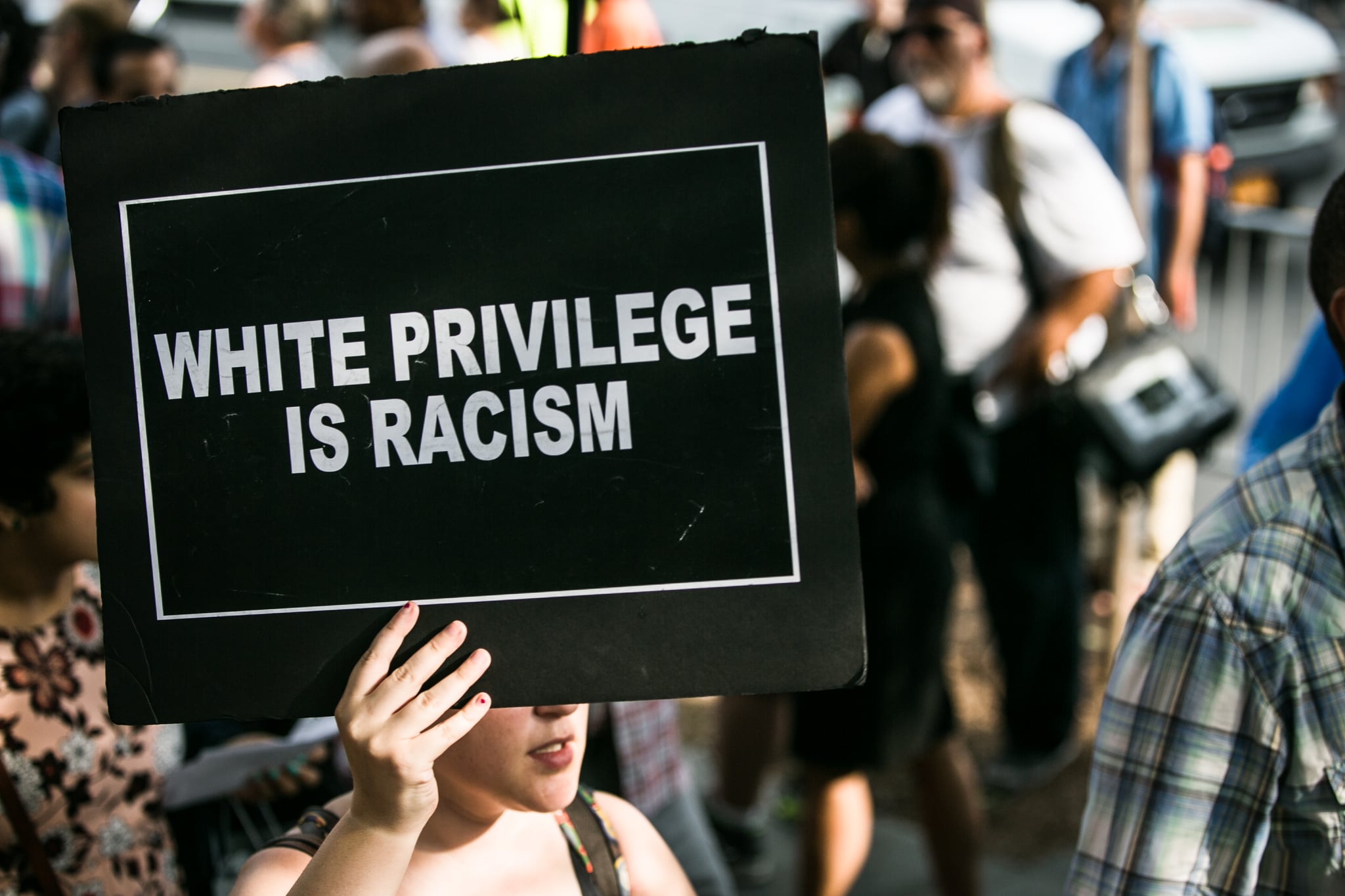 A protestor holds a sign reading, "WHITE PRIVILEGE IS RACISM" on July 7, 2016. Thousands rallied calling for an end to the epidemic of unsanctioned police murder occurring primarily in black communities across the United States. (Photo by Karla Ann Cote/NurPhoto via Getty Images)