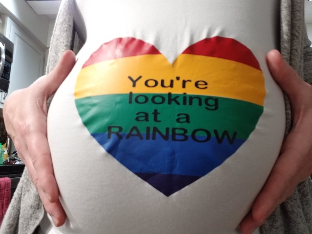 "I actually wore this around Disney World on vacation and received several hugs from complete strangers. Goofy even pointed at my belly, drew a heart with his hands and blew me a kiss. One of the greeters who hands out buttons to first time guests told me she knew exactly what my shirt meant, got teary with me, and gave me the most sincere embrace. While waiting in line for rides mamas would excitedly introduce me to their 'rainbows.' The whole day was filled with so much love and support."