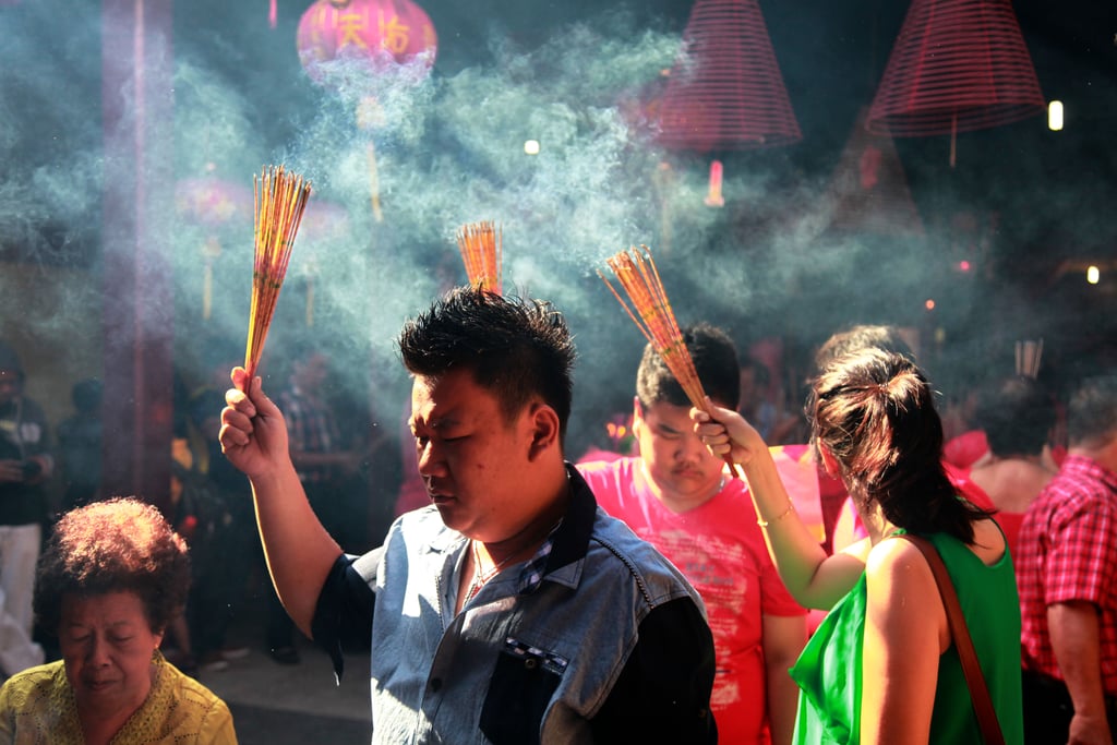 People held up incense sticks during prayer ceremonies in Bali.