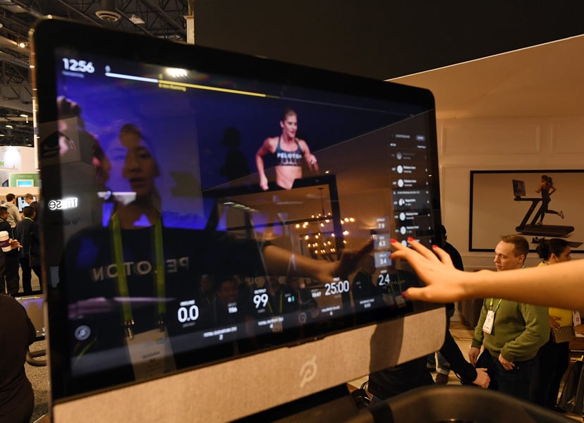 LAS VEGAS, NV - JANUARY 11:  Maggie Lu is reflected in a touch screen as she demonstrates how to select a class on a Peloton Tread treadmill during CES 2018 at the Las Vegas Convention Center on January 11, 2018 in Las Vegas, Nevada. The USD 3,995 workout