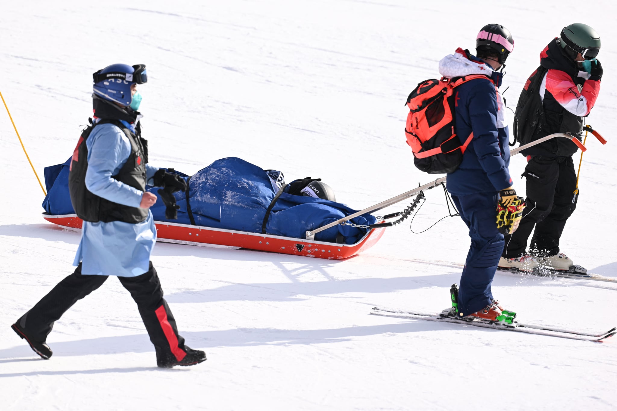 USA's Nina O'Brien (2nd L) is pulled away on a stretcher by medical staff after she crashed in the second run of the women's giant slalom during the Beijing 2022 Winter Olympic Games at the Yanqing National Alpine Skiing Centre in Yanqing on February 7, 2022. (Photo by Fabrice COFFRINI / AFP) (Photo by FABRICE COFFRINI/AFP via Getty Images)