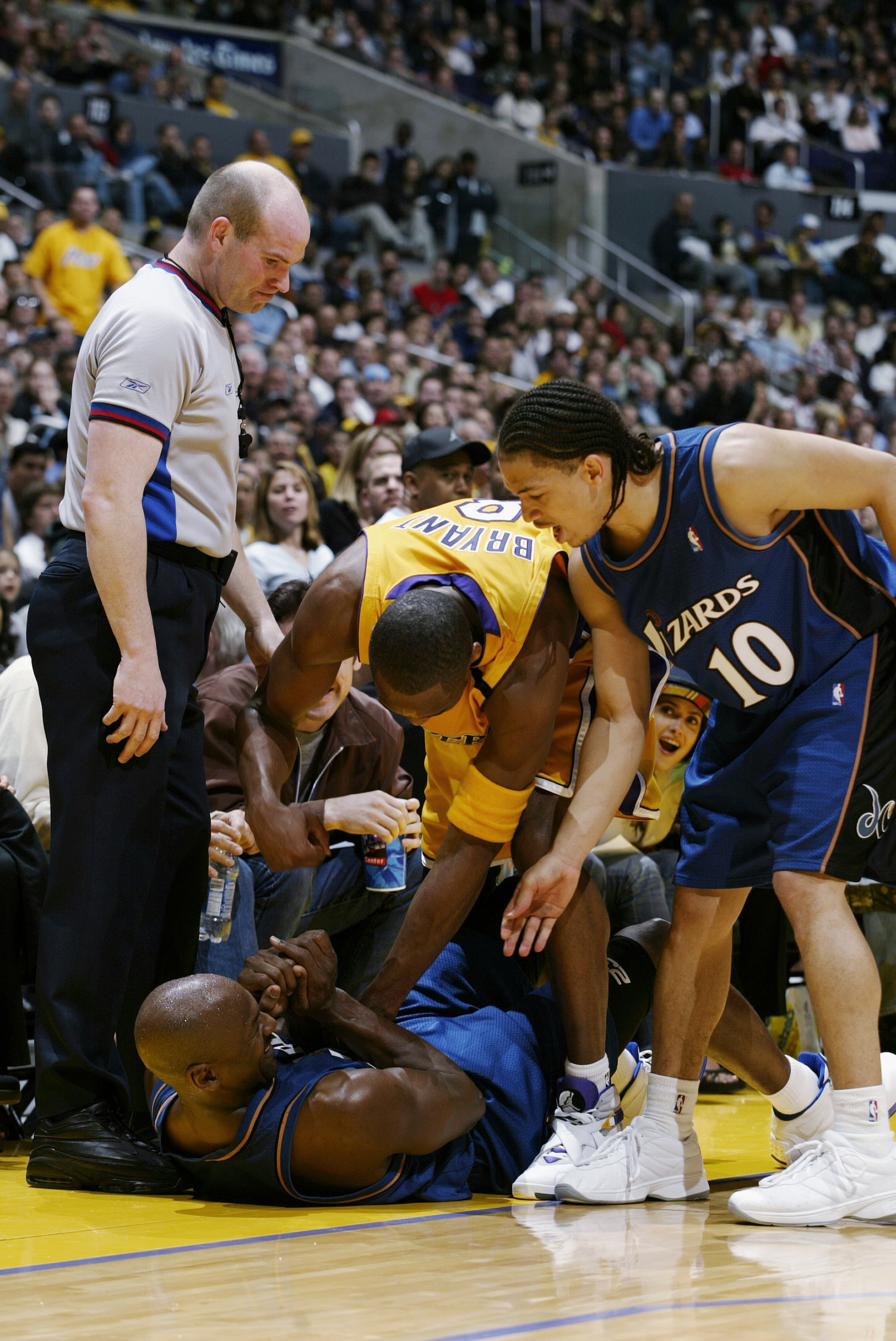 LOS ANGELES - MARCH 28:  Michael Jordan #23 of the Washington Wizards is helped up from the floor by teammate Tyronn Lue #10 and Kobe Bryant #8 of the Los Angeles Lakers during the game at Staples Centre on March 28, 2003 in Los Angeles, California.  The Lakers won 108-94.  NOTE TO USER: User expressly acknowledges and agrees that, by downloading and/or using this Photograph, User is consenting to the terms and conditions of the Getty Images Licence Agreement.  (Photo by Robert Laberge/Getty Images)