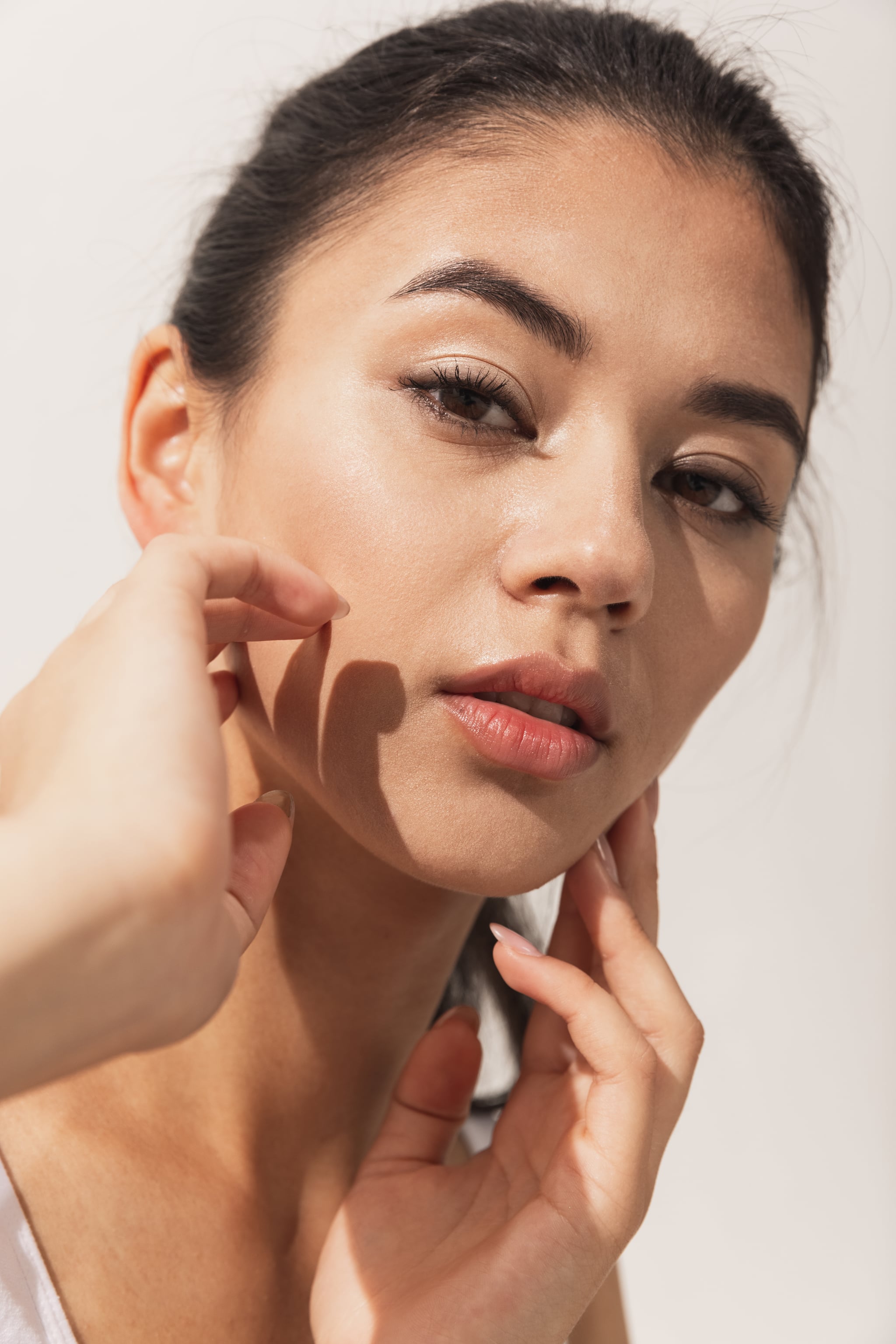 Tender, fragile.  Cropped image of beautiful female face with plump lips isolated on white studio background.  Close up.  Concept of female beauty and tenderness