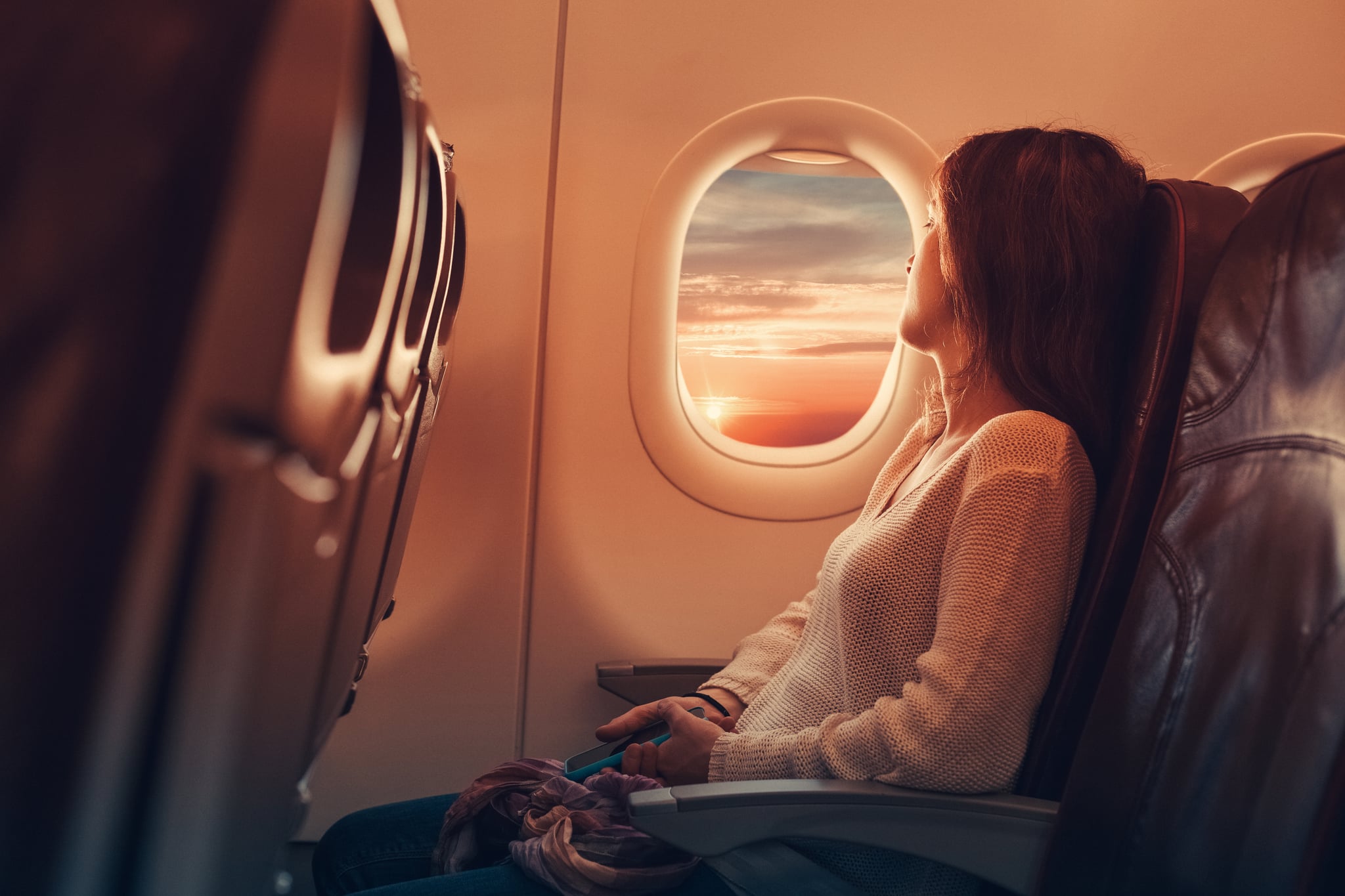 Woman in airplane looking through the window