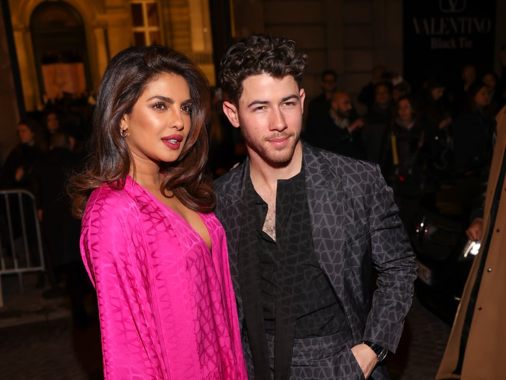 It's her dream house and we're all just living it. On March 5, Priyanka Chopra attended the Valentino womenswear show during Paris Fashion Week dressed in an all-pink Barbiecore ensemble. The look featured a silky dress by the designer with a plunging neckline almost resembling a robe. Chopra paired the lightweight slip with a bright bubblegum trench coat with a side bow detail adding to the sweet aesthetic. Her closed-toe boots and matching purse were emblazoned with the same monogram print as the one on her dress, creating a fully monochromatic look. 
Chopra worked with acclaimed celebrity stylist Law Roach, whose previous work has appeared on stars like Zendaya and Kerry Washington. She wore jewelry from Bulgari, including delicate sparkling bracelets and tiny hoop earrings, and swept her hair into an exaggerated side part for additional drama. The former Bollywood star arrived at the show hand-in-hand with her husband, Nick Jonas, with whom she shares 1-year-old baby Malti. And although Jonas himself was not dressed in pink, he also wore a monogrammed Valentino suit to complement Chopra's outfit.  
With Greta Gerwig's "Barbie" movie on the way, Barbiecore has taken Hollywood by storm. Derived in part from Y2K fashion, the trend found inspiration in the glamour and campiness of Barbie dolls, including their love for pink and over-the-top sense of style. Other stars who have shown love to the Barbiecore aesthetic include Selena Gomez, who wore towering hot-pink platforms and a matching miniskirt on "Saturday Night Live," and Anne Hathaway, whose glittery sequin minidress was equal parts plastic and fantastic. 
Read on to see how Chopra put her own spin on the trend. 

    Related:

            
            
                                    
                            

            Ciara Tests the "No-Pants" Trend in a Completely See-Through Cutout Sweater