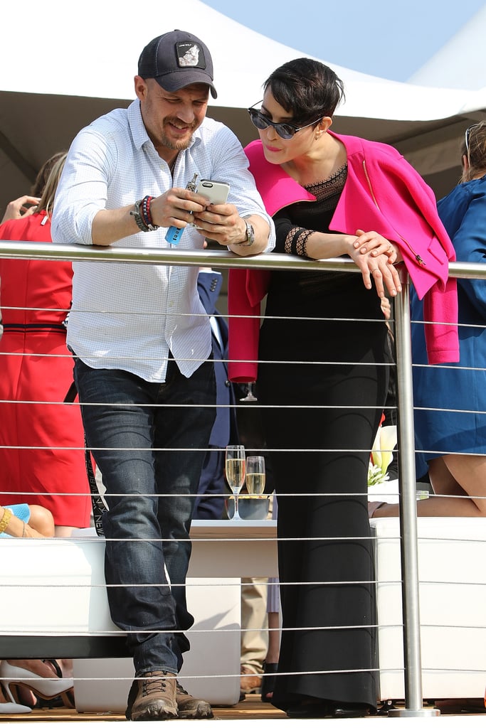 Checking out his phone with Noomi Rapace at the Audi Polo Challenge in 2016.