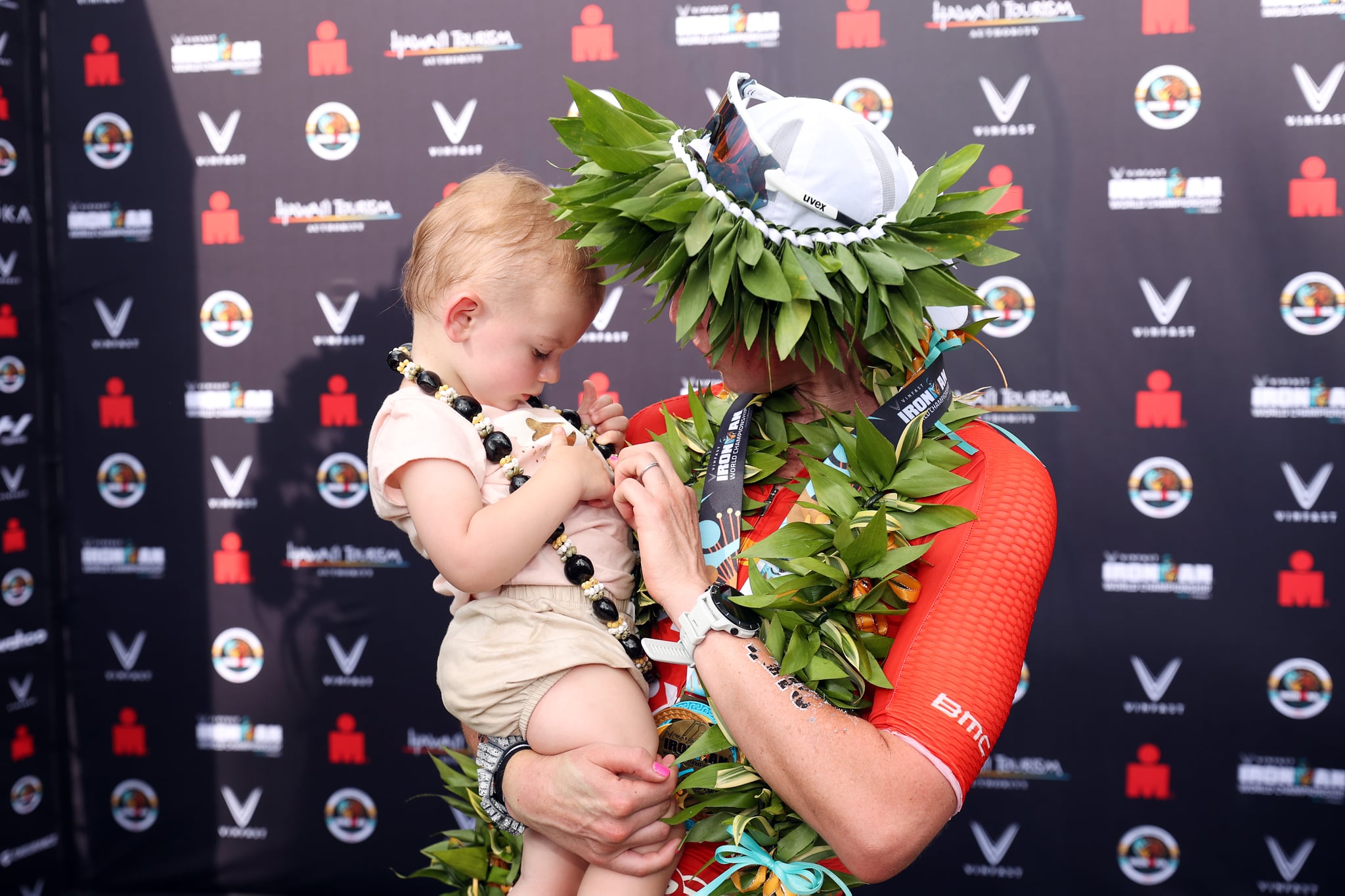 KAILUA KONA, HAWAII - OCTOBER 06: Chelsea Sodaro celebrates with her daughter Skylar after winning the Ironman World Championships on October 06, 2022 in Kailua Kona, Hawaii. (Photo by Ezra Shaw/Getty Images for IRONMAN)