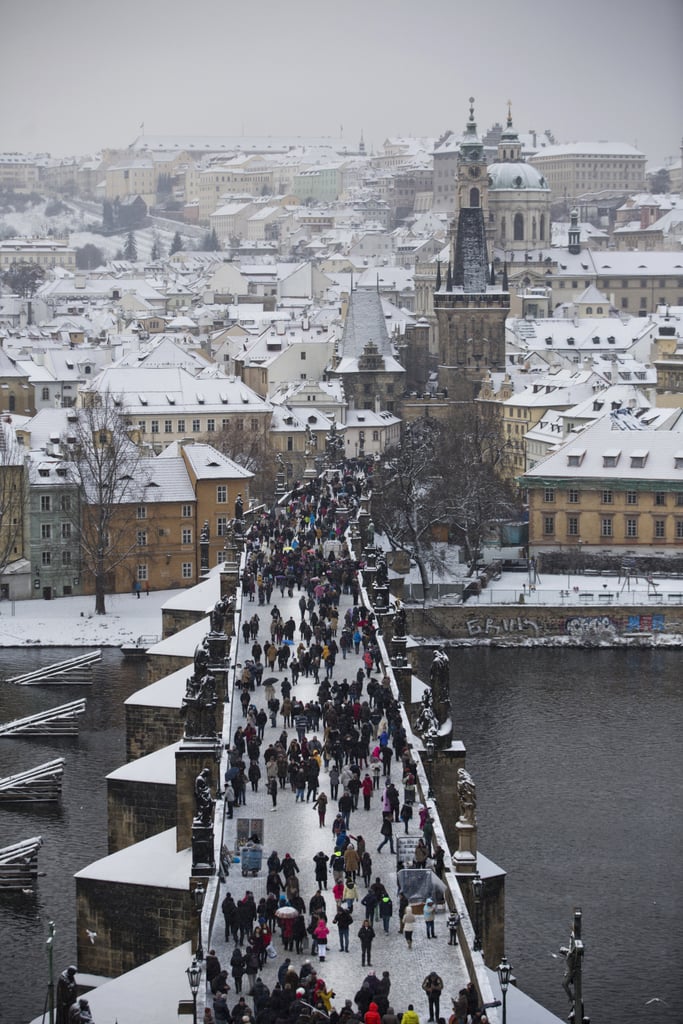 People walked along Prague's snowy Charles Bridge.