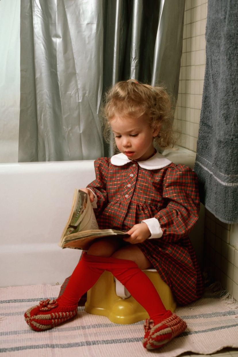 2 year-old girl sitting on training potty seat. (Photo by James Marshall/Corbis via Getty Images)