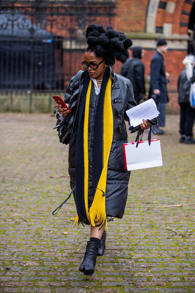 A black puffer dress is an eclectic and practical choice, which is made even more interesting with a punchy canary-yellow scarf.
