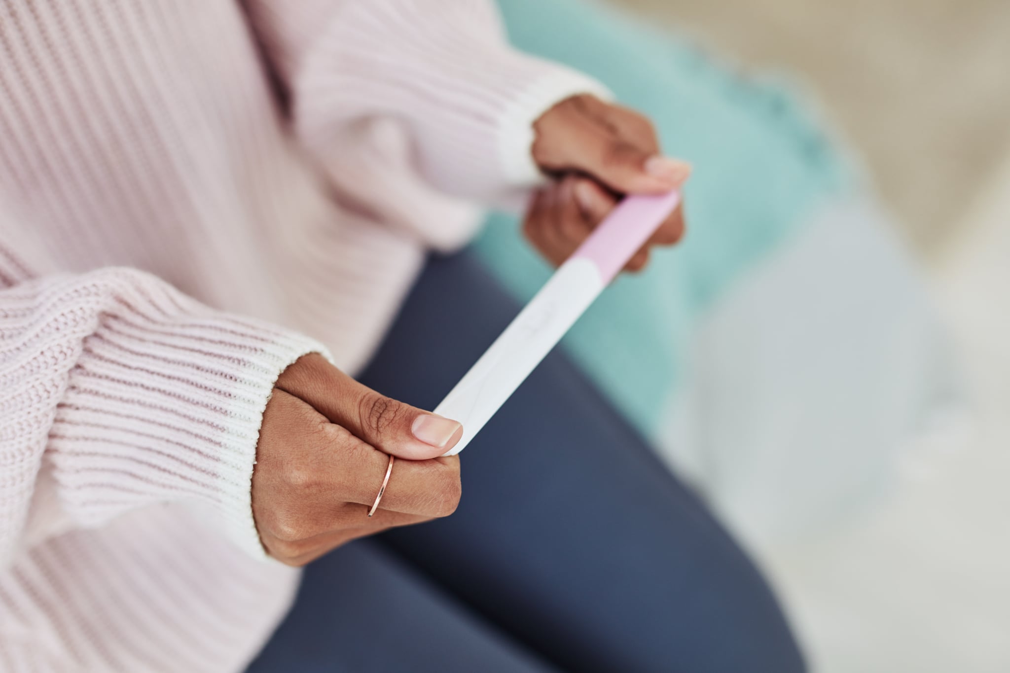 Cropped shot of an unrecognisable woman sitting on her bed alone and waiting for a pregnancy test result at home