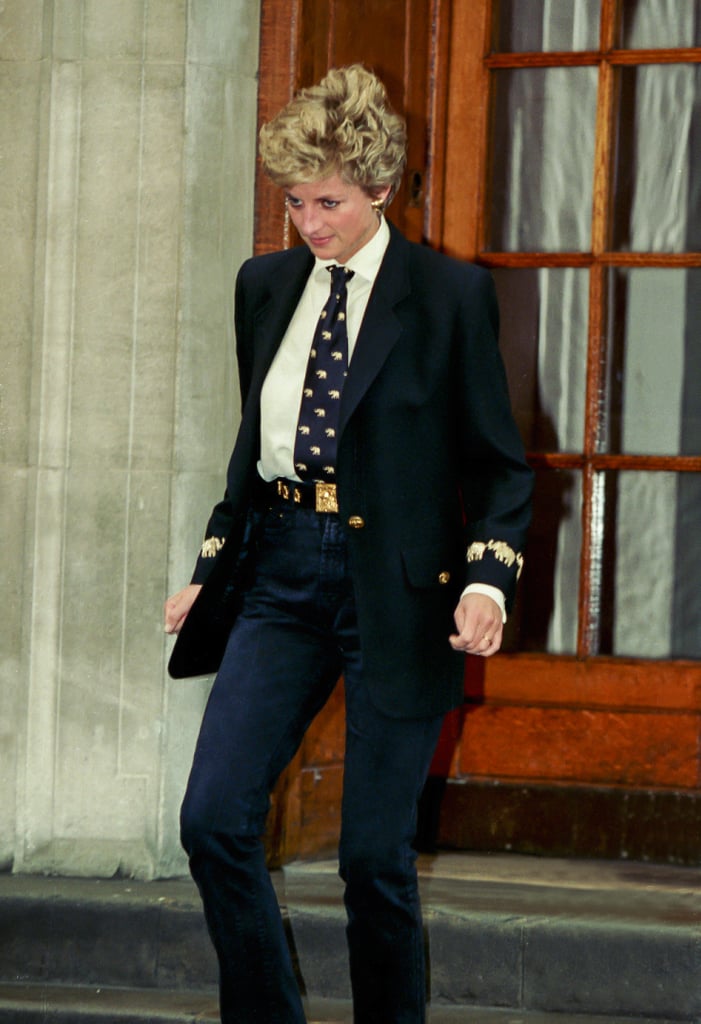 While visiting her brother Charles Althorp's newborn baby at the hospital, Diana chose dark denim mom jeans. She styled them with an oversize blazer, tie, and belt — all featuring a gold elephant print.