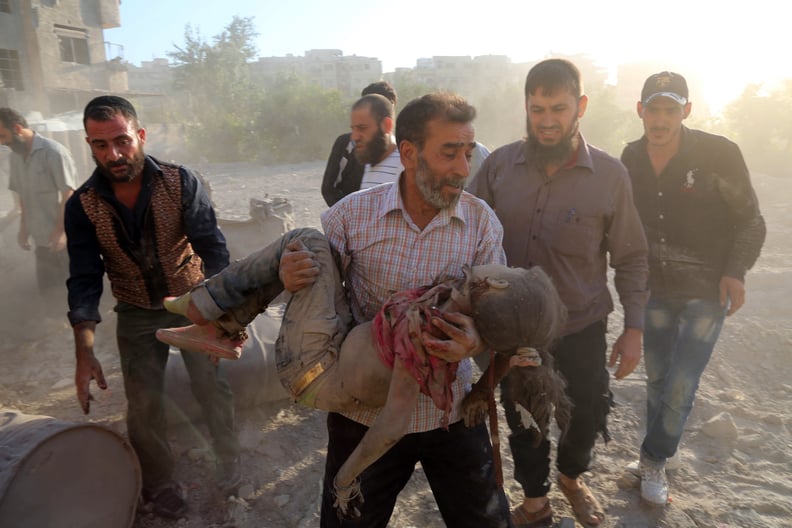 A man carries the body of a young girl after an airstrike in rebel-held territory near Damascus.