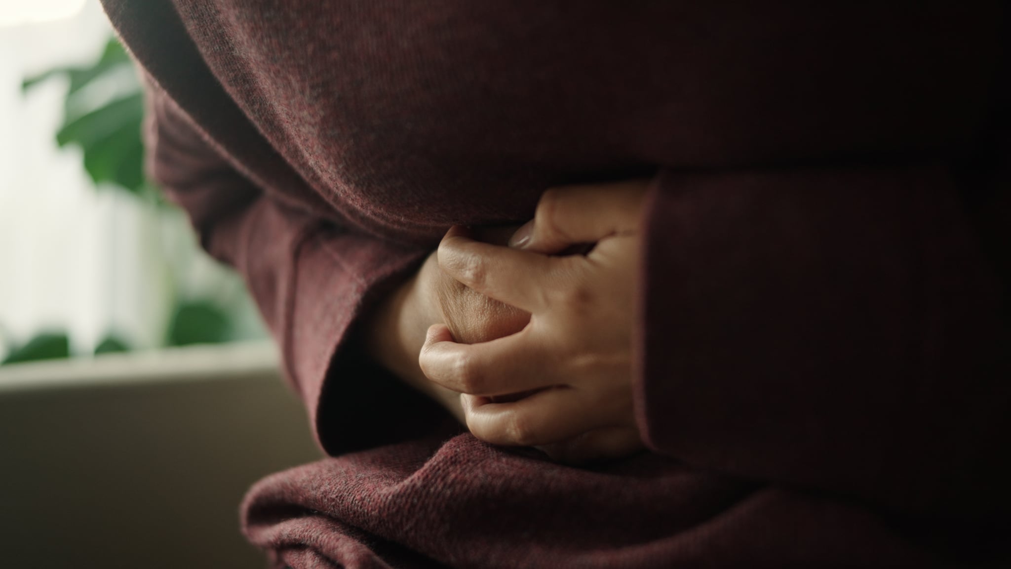 Woman having a stomachache on sofa at home.