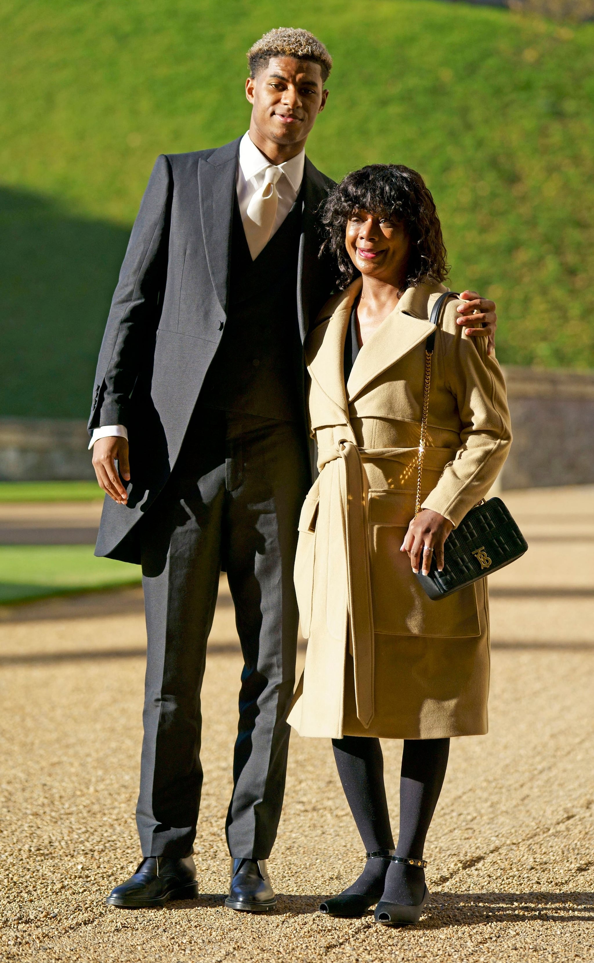 Manchester United and England footballer Marcus Rashford poses his mother Melanie Rashford before being appointed a Member of the Order of the British Empire (MBE) for services to Vulnerable Children in the UK during the Covid-19 pandemic, at an investiture ceremony at Windsor Castle in Windsor, west of London on November 9, 2021. (Photo by Andrew Matthews / POOL / AFP) (Photo by ANDREW MATTHEWS/POOL/AFP via Getty Images)