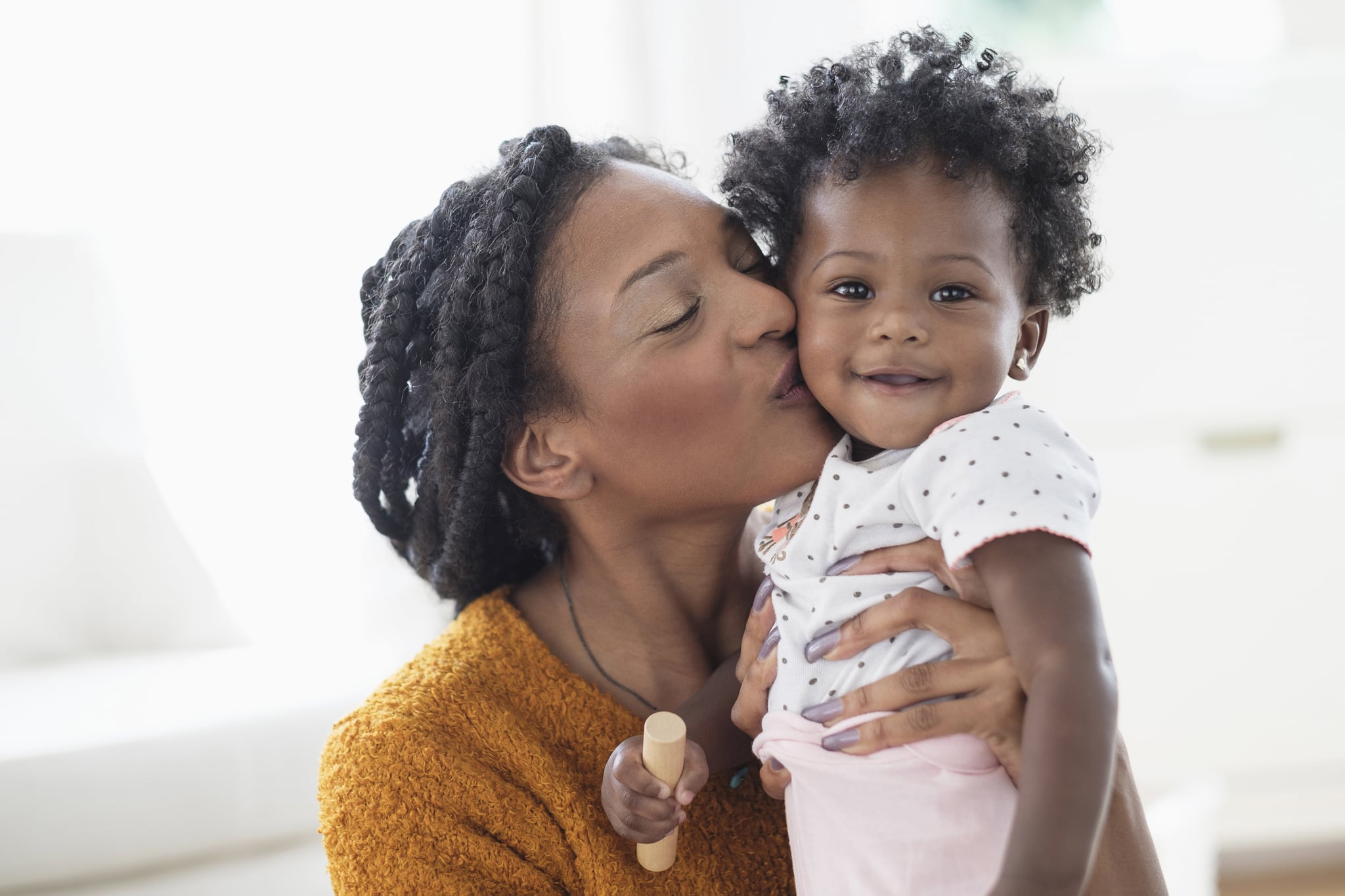 Black mom kissing baby on the cheek