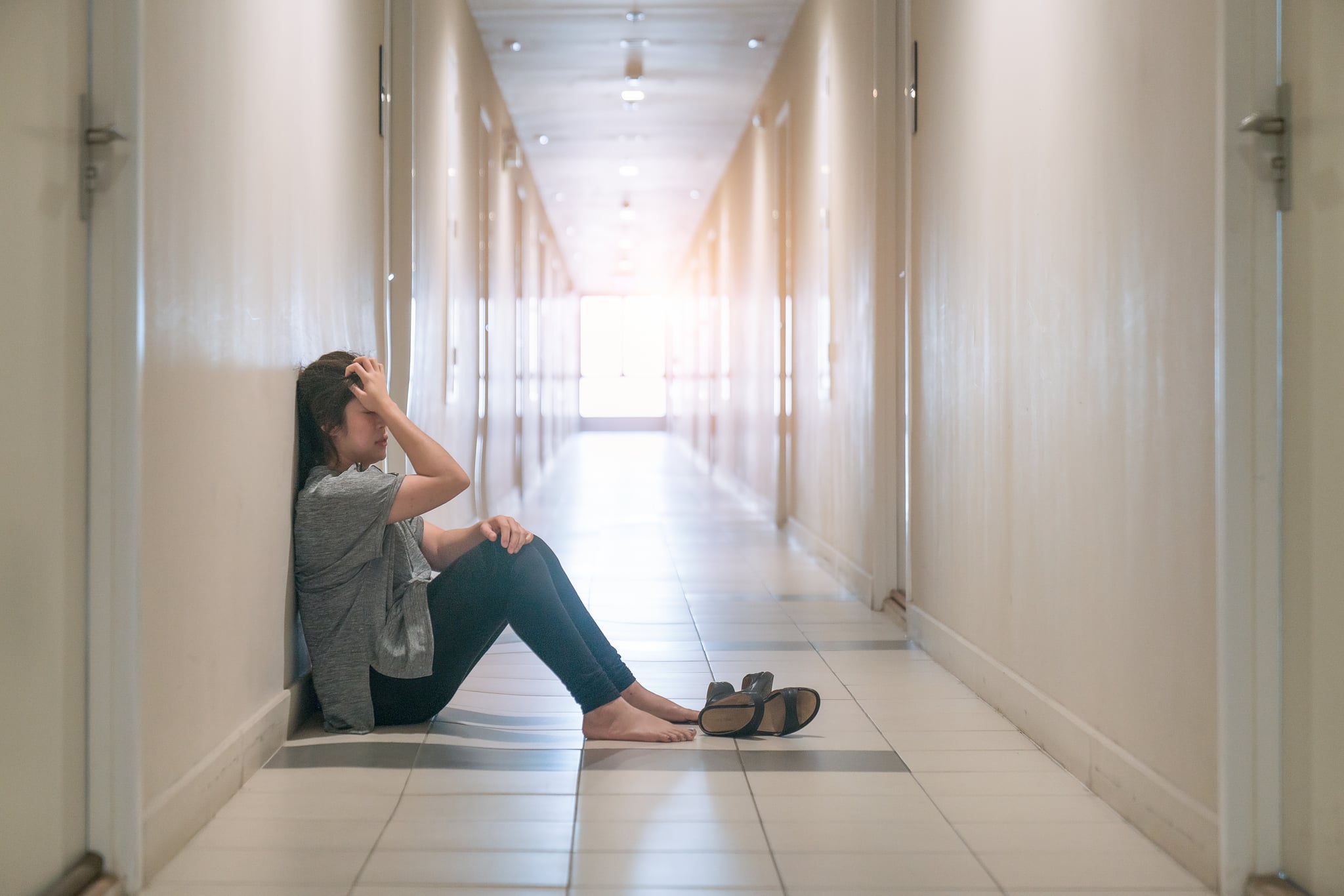 woman suffering from depression sat in the corridor and cried.