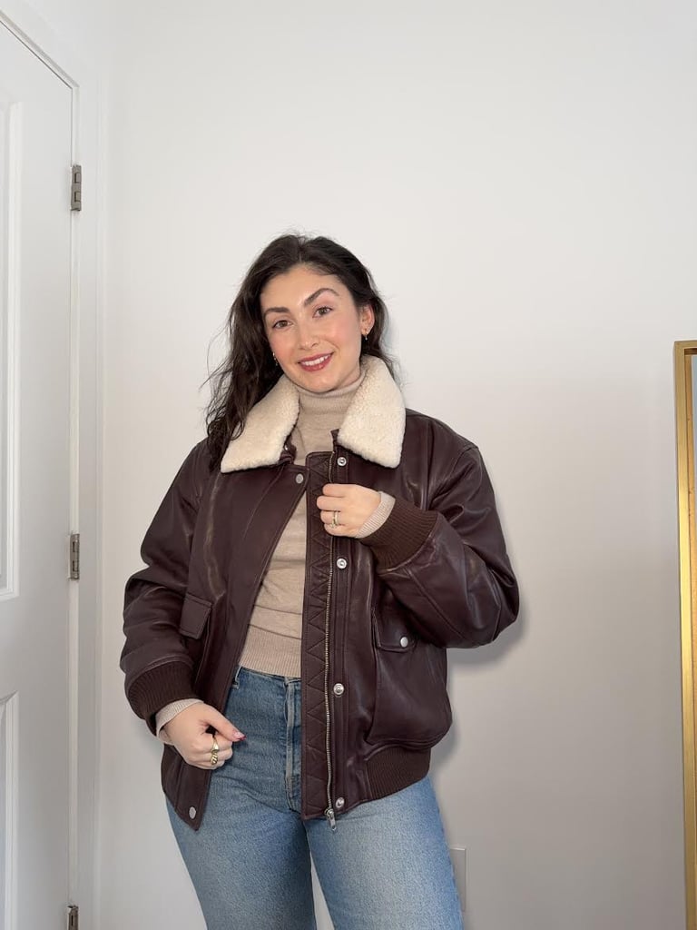 Quince 100% Leather Shearling Trim Aviator Jacket ($300)
Height: 5'3"
Size: Large (sized up)
"I've been on the hunt for a baggy, lived-in-looking leather jacket to add to my collection of coats, and this aviator jacket from Quince immediately caught my eye. I absolutely love the shearling collar (bonus points because it's removable) and the warm, chocolaty-brown color. I opted to size up from my usual medium coat size and got a large one for a looser, oversize fit. It's baggy, but the waist and cuffs have elastic to cinch in those areas, keeping the jacket from swallowing me. While I don't think this coat would be warm enough to withstand a Northeast winter, it's a great in-between coat for those days when you need more than a light jacket but don't want to drag out anything too heavy-duty. If you layer a thick sweater underneath it (and there's plenty of room to do that), I'm sure it would keep you quite toasty." — Jessica Harrington, beauty section lead
Rating: