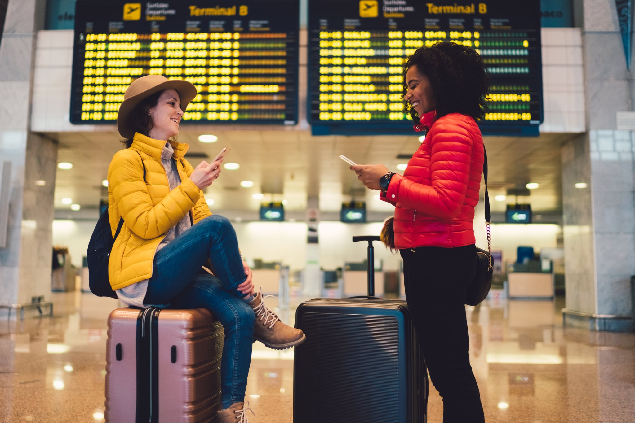 Happy friends at the airport in Barcelona waiting for their flight