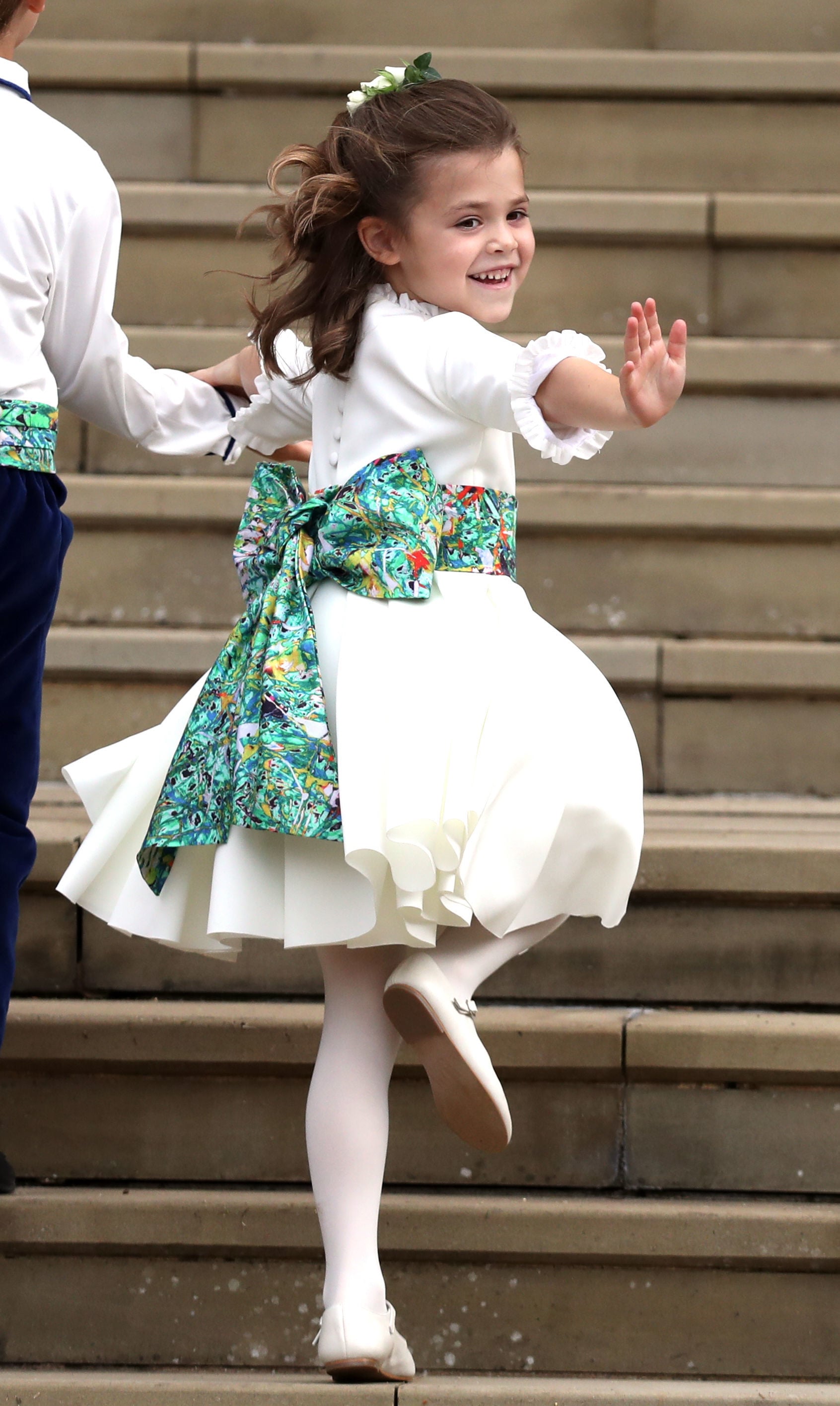 Bridesmaid Theodora Williams, daughter of Robbie Williams and Ayda Field, waves a she arrives to attend the wedding of Britain's Princess Eugenie of York to Jack Brooksbank at St George's Chapel, Windsor Castle, in Windsor, on October 12, 2018. (Photo by Steve Parsons / POOL / AFP)        (Photo credit should read STEVE PARSONS/AFP via Getty Images)