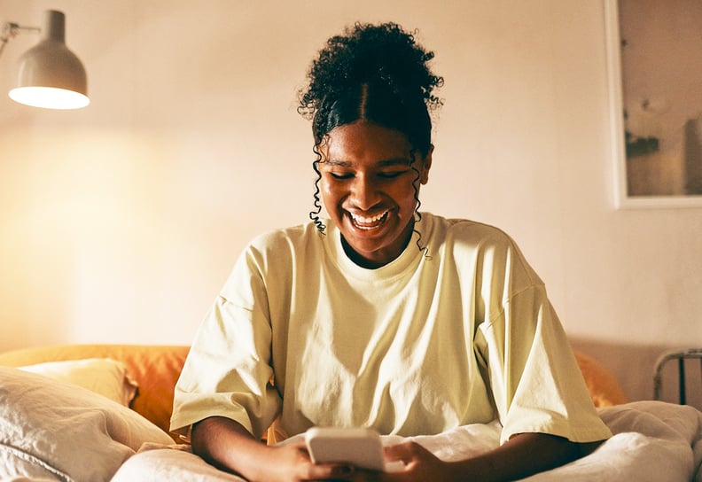 woman on couch looking down at her phone