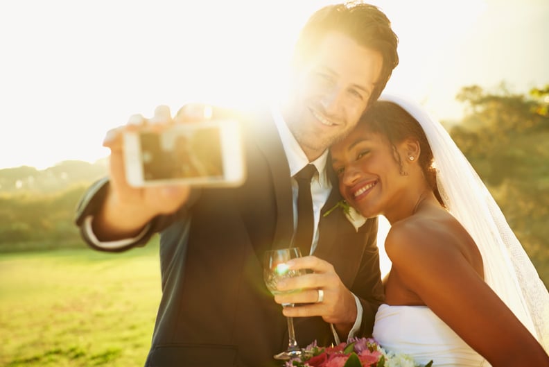 Shot of a newlywed couple taking a selfie with a cellphone
