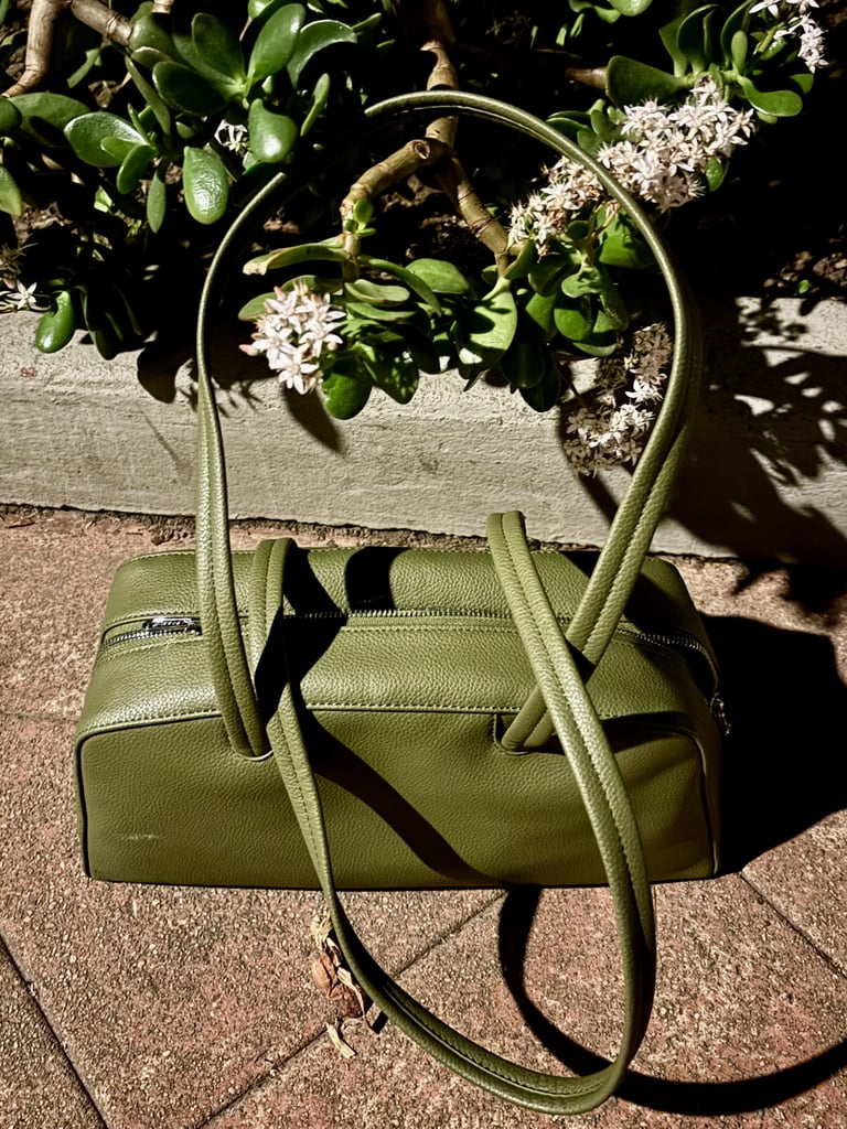 Baggu Recycled Leather Bowler Bag ($95, originally $190)
I've always loved Baggu's nylon crossbody bags, and their recycled leather line takes their trendy silhouettes to a new level. The size of this bowler bag is ideal: I can fit my phone, sunscreen, sunglasses, a film camera, lip gloss, and more in it, but it's compact and easy to carry around. The Loden color is a shade of leafy green very much fit for spring.