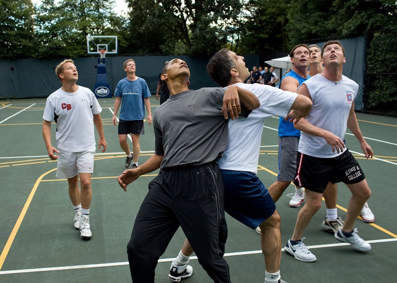 The president, extremely competitive in sports and policy, jockeying for a rebound with congressmen during a basketball game.