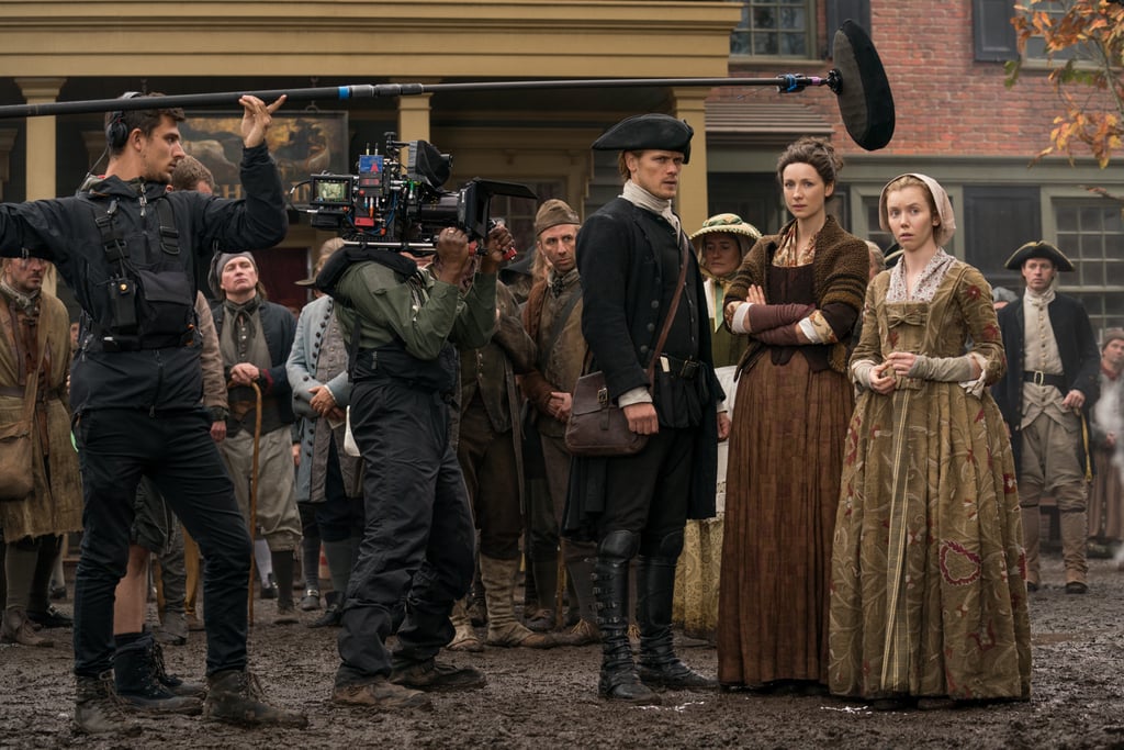 Heughan, Balfe, and Lauren Lyle (Marsali) get serious on set during a scene from season four.