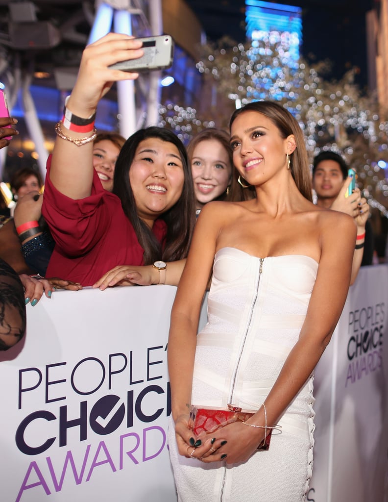 Jessica Alba posed for a fan's picture while walking the People's Choice Awards red carpet.