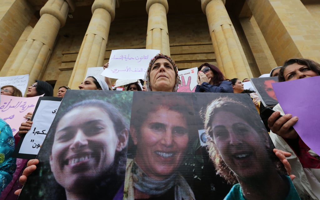 Women in Lebanon held up portraits of domestic-abuse victims.