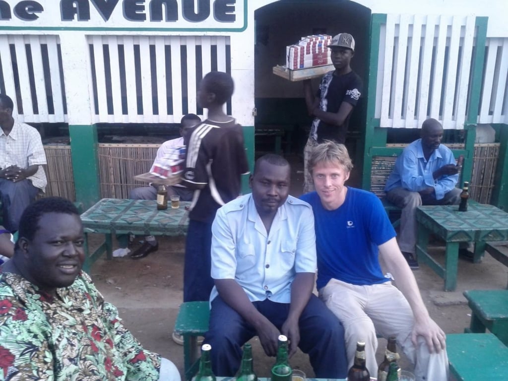 Here Garfors enjoys a beer with a local police officers and cassette-tape salesman in N'Djamena, the capital and largest city in Chad.