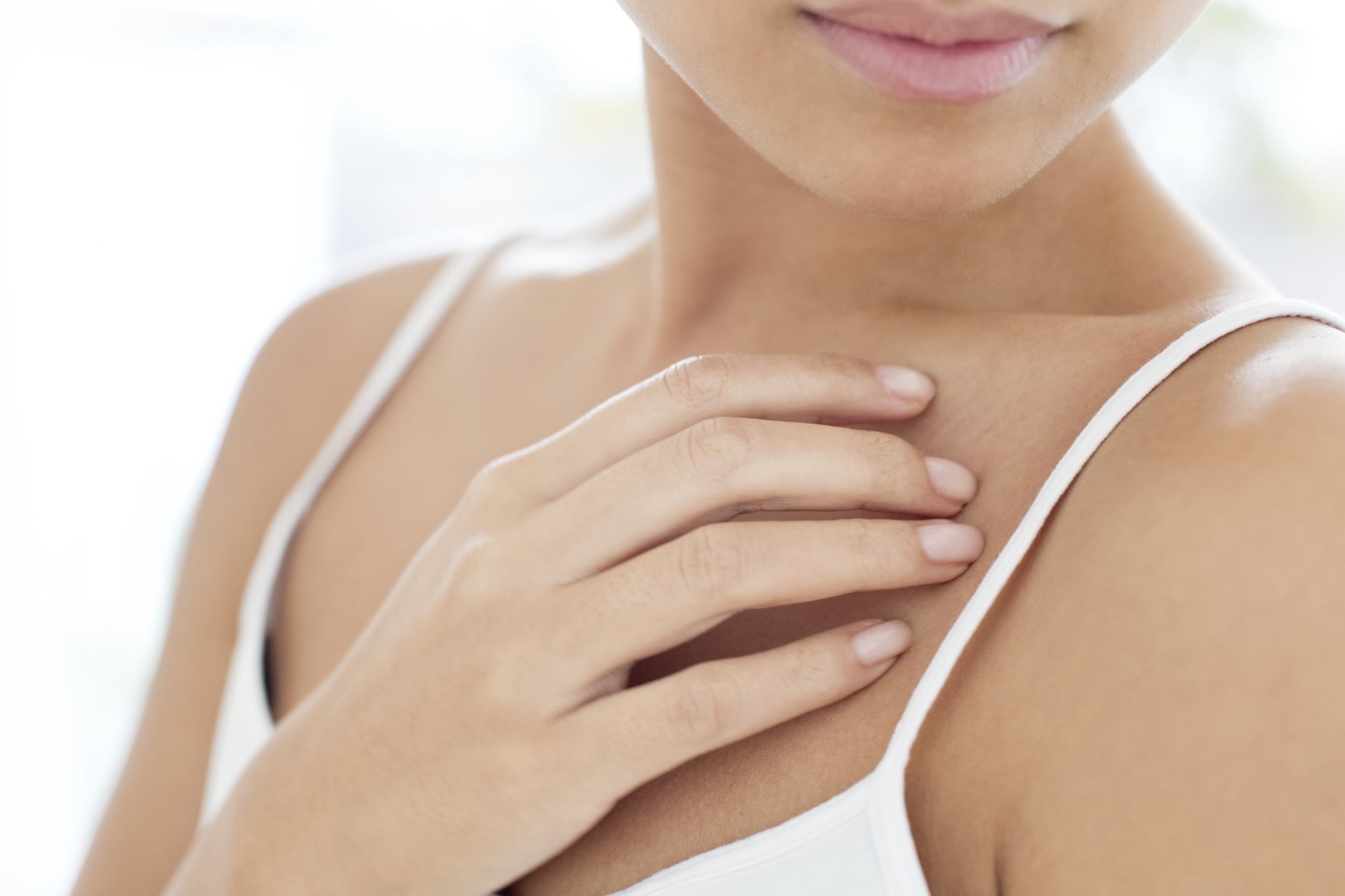 Young woman touching chest.