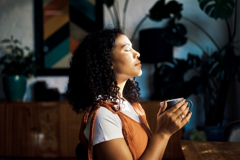 Relax, peace and coffee with a woman drinking a drink of caffeine and meditating in her home with her eyes closed. Mental health, wellness and zen with a young female enjoying calm, quiet tranquility