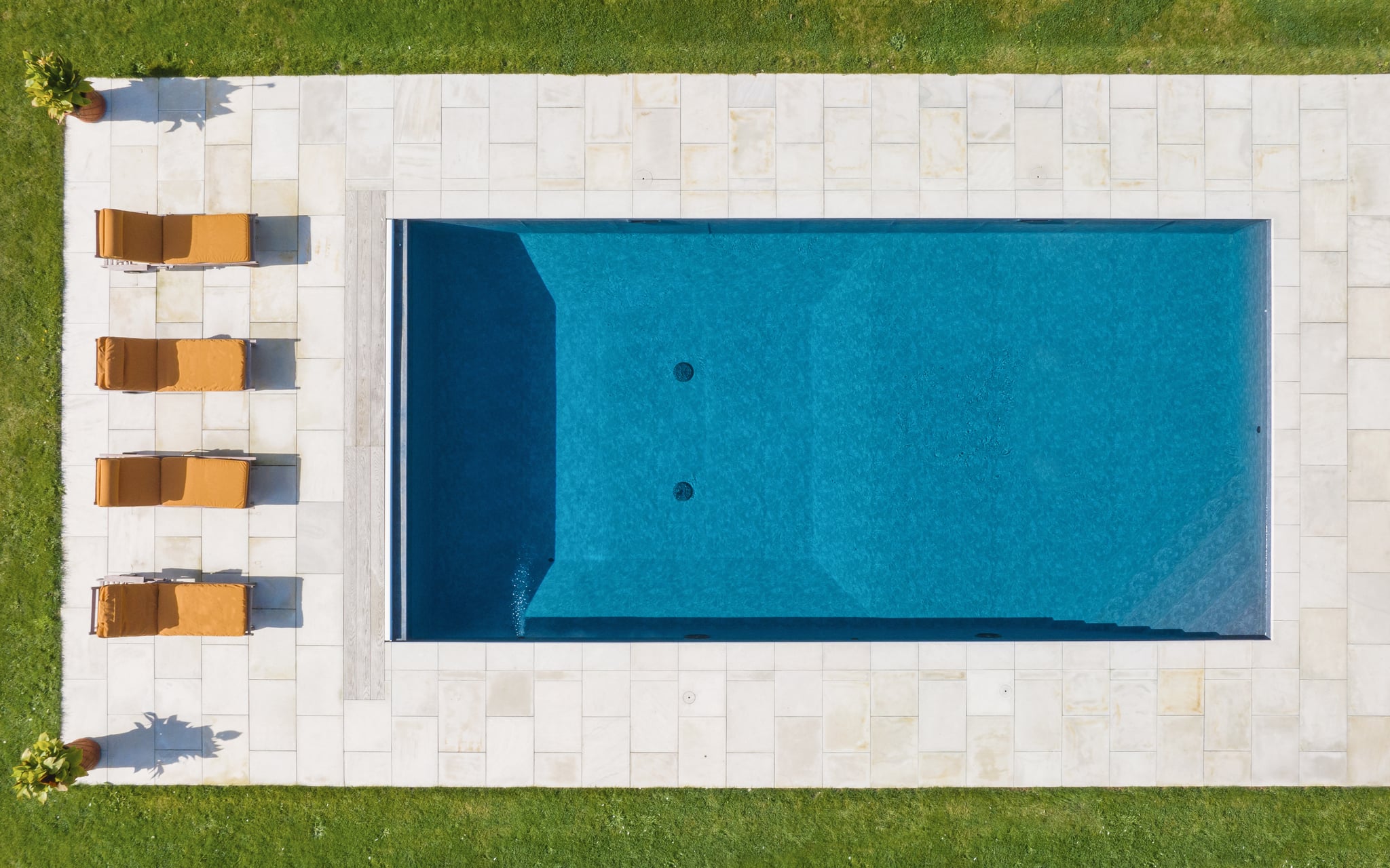 overhead view of a swimming pool and lounge chairs
