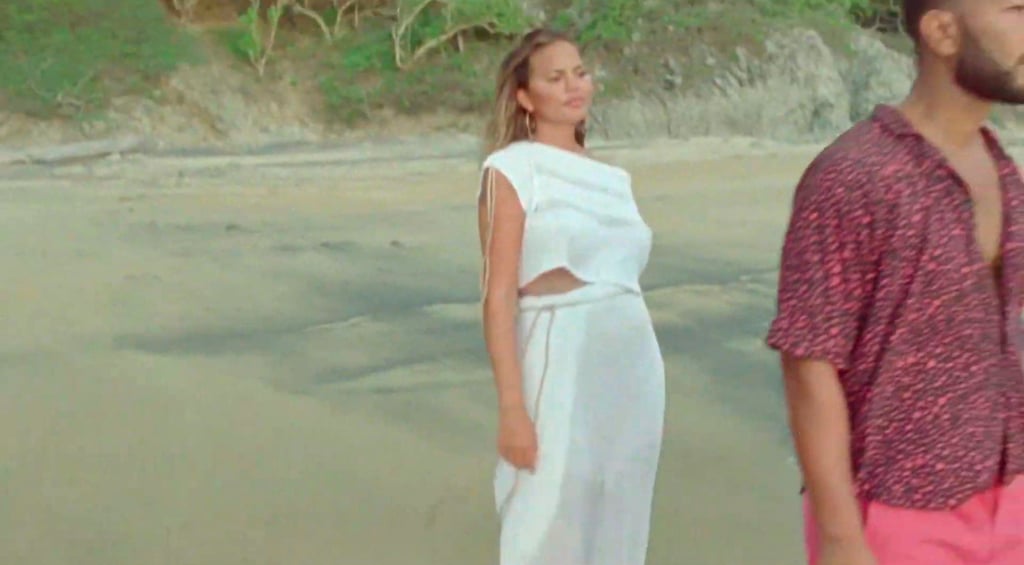 Chrissy Teigen Reveals Pregnancy in a White Dress in "Wild"