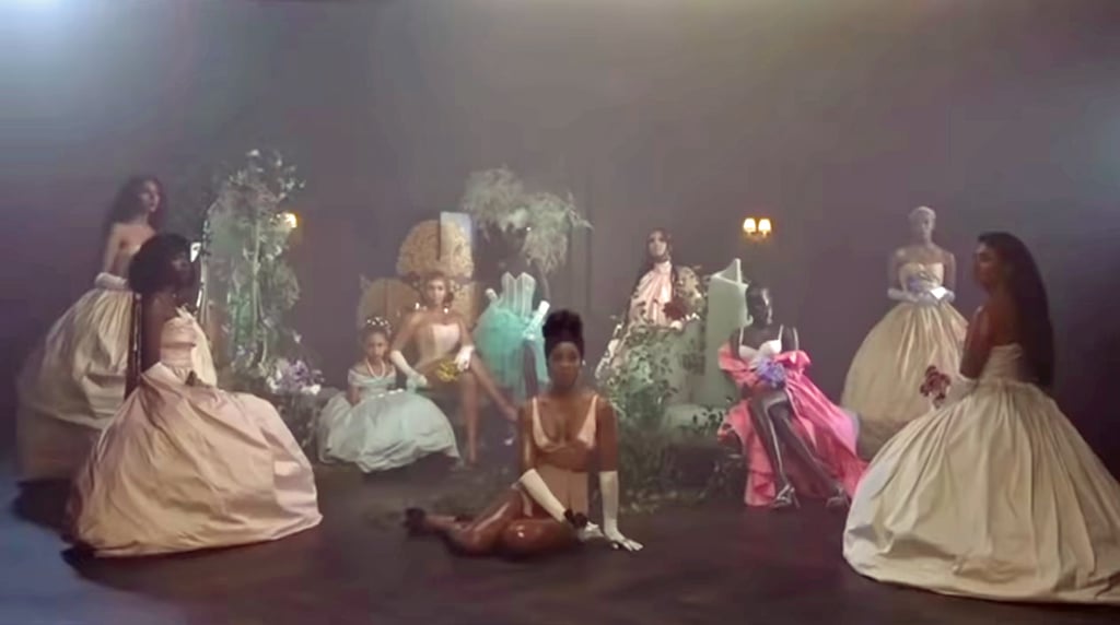 Beyoncé wears a strapless corset with gloves, sitting by Blue Ivy's side, who wears an off-the-shoulder ballgown.