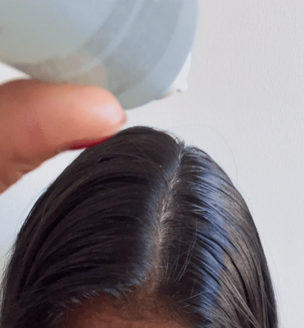 Woman applying the Briogeo Scalp Revival Rosemary Pre-Wash Oil to her scalp and massageing it in.