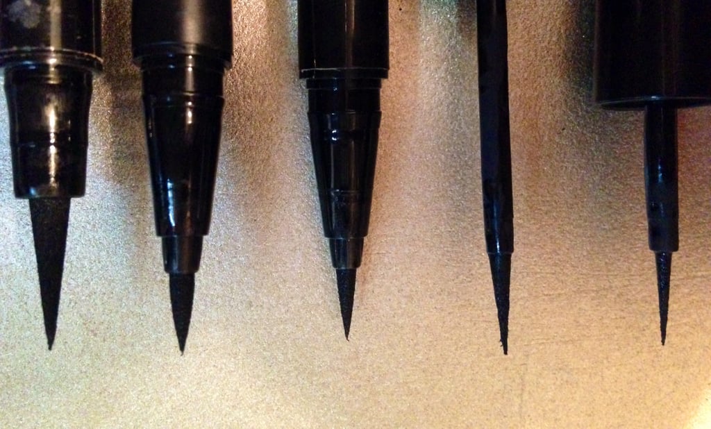 The Revlon Skinny Liner is on the far right, and clearly boasts the slenderest brush from base to tip out of all of them. 
What's more, this product also features a raven-black formula that dries quickly with a matte finish, which I definitely prefer to a shiny one. To me, a matte texture gives you more of a doe-eyed retro look as opposed to a glitzier patent-leather-like one. I also had zero problems with the color fading or imprinting into my crease throughout the day, which I've struggled with when using other liners. The only caveat is that I wish the applicator was a little firmer. It was too flexible for my taste. I find that stiffer brushes offer more control because they retain their arrow-straight edge better, but that's admittedly a personal preference.