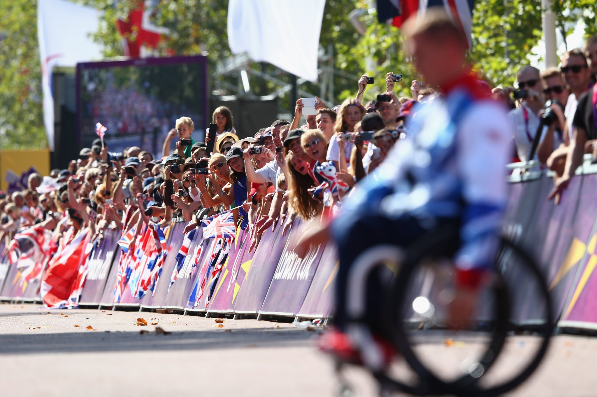 LONDON, ENGLAND - SEPTEMBER 09:  David Weir of Great Britain is cheered by the crowds as he makes his way to the winners podium on The Mall after his fourth gold medal of the Paralympic Games after victory in the Men's T54 Marathon on day 11 of the London 2012 Paralympic Games at Olympic Stadium on September 9, 2012 in London, England.  (Photo by Michael Steele/Getty Images)