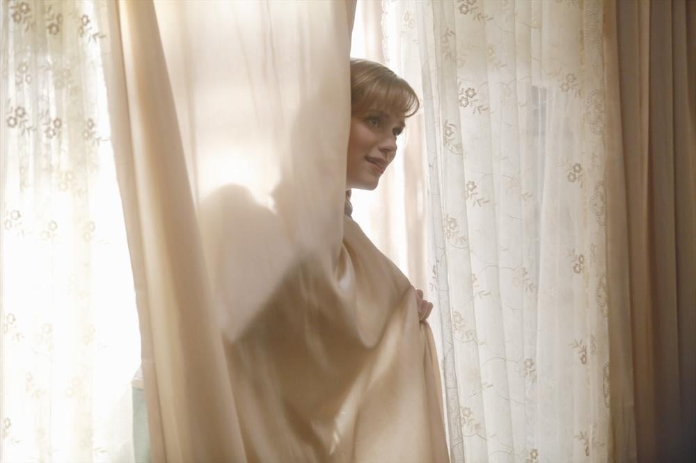 Anna hides in the curtain.